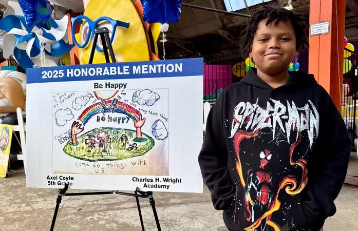  student standing by his art project